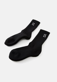 Sorte bomuldsstrømper med ribbede mansjetter og et hvidt trykt "II" design. De har en glat tekstur og er af mellemhøjde til læggen.