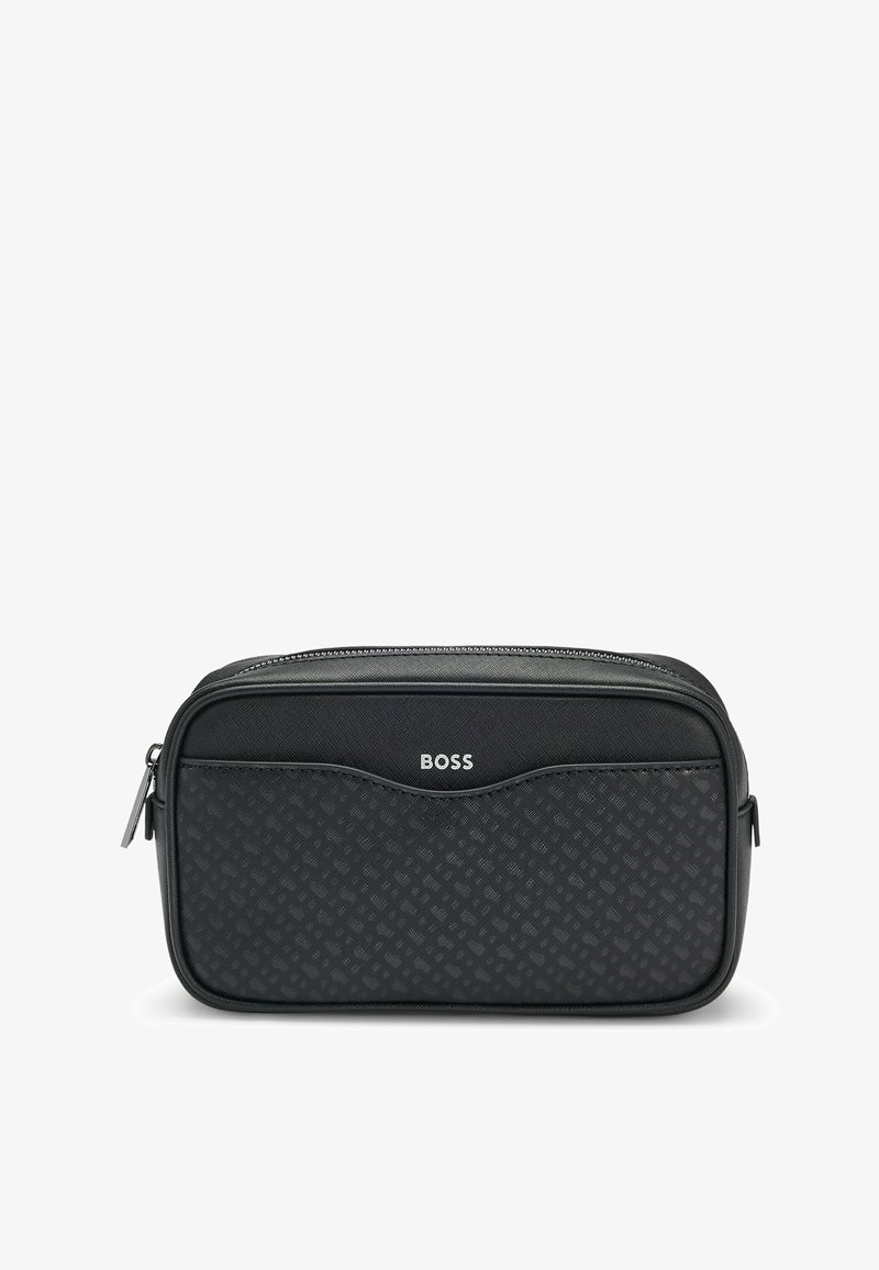 Trousse à cosmétique noire à fermeture éclair avec un devant texturé et motif, dotée d'une bordure lisse et d'un logo argenté en haut. Forme rectangulaire compacte.