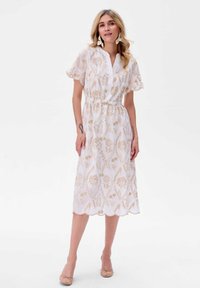 Witte midi-jurk met goudkleurig bloemenpatroon, korte mouwen, V-hals, elastische taille en gegolfde zoom. Lichtgewicht stof met een gestructureerde afwerking.