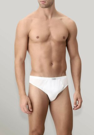 Slip in cotone bianco da uomo con design aderente, cintura elasticizzata e cuciture minime, esposti su uno sfondo neutro.