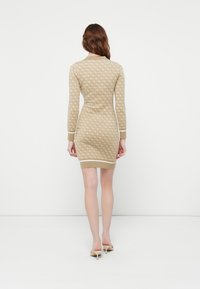 Rochie tricotată în bej deschis, cu un model în diamante, manșete și tiv contrastante. Siluetă ajustată, lungime până la mijlocul coapsei, textură netedă.