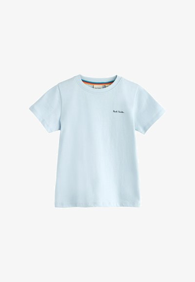 Gaiši zils kokvilnas T-krekls ar īsām piedurknēm, apaļu apkakli un mazu melnu izšuvumu uz krūšu kabatas. Gluda tekstūra, ikdienišķs dizains.