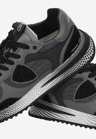 Scarpe sportive grigie realizzate in pelle e mesh, con una tomaia testurizzata, accenti neri, una suola maculata bianca e lacci in contrasto.