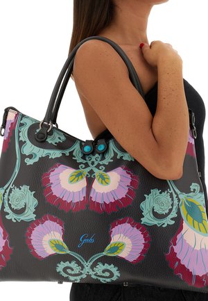 Borsa in pelle nera con grandi motivi floreali in tonalità di rosa, viola e verde acqua. Decorata con accessori blu e dotata di due manici.