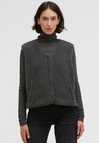 Gray fleece vest with a v-neck, front button closure, and two side pockets. Features a textured, soft exterior and trim edges.