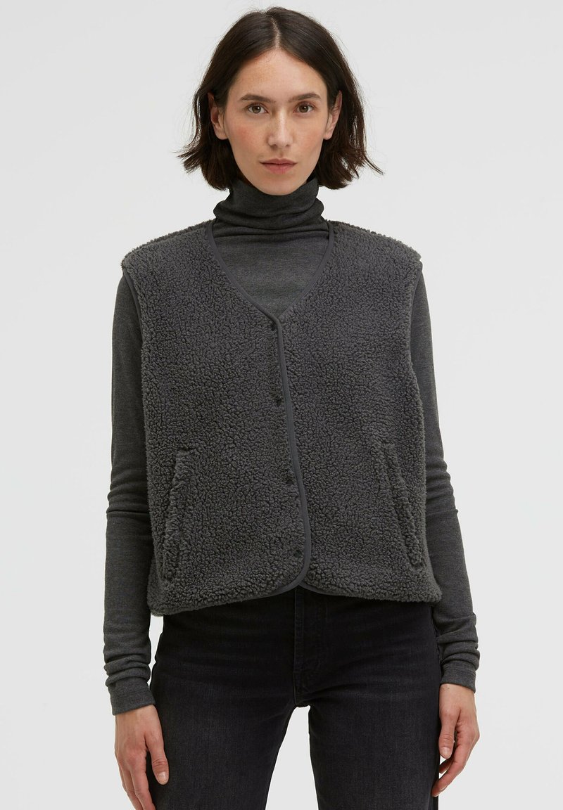 Gray fleece vest with a v-neck, front button closure, and two side pockets. Features a textured, soft exterior and trim edges.