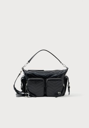 Mala de mão em couro acolchoado preto, com dois bolsos frontais com fecho éclair, pega superior, alça de ombro ajustável e detalhes em metal prateado.
