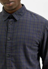 Camicia a quadri blu e bordeaux con colletto button-down e placket, caratterizzata da bottoni a contrasto e tessuto texture.