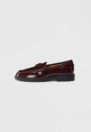 Tume burgundia nahast loafer musta tallaga, penny riba detailiga ja madala kontsaga, nähtav välisküljelt valgel taustal.