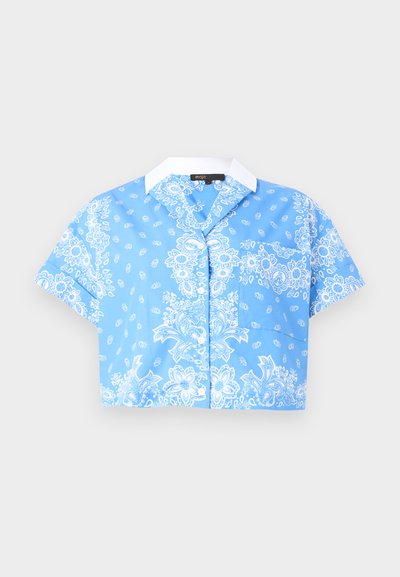 Κοντομάνικο μπλε κοντό μπλουζάκι με λευκό εμπριμέ πασλέ μοτίβο και λευκό μυτερό γιακά, με κουμπιά μπροστά και τσέπη στο στήθος.