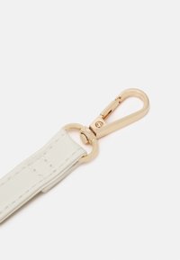 Biały skórzany pasek z metalowym złotym klipsem na jednym końcu. Pasek jest płaski, z detalami przeszyć i gładką fakturą.