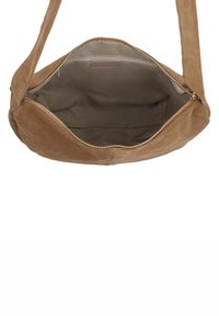 Vaaleanruskea mokkalaukku, jossa vetoketjusuljenta. Pehmeä tekstuuri, tilava sisätila, jossa yksinkertainen kangasvuori ja ilman ulkopuolisia taskuja.