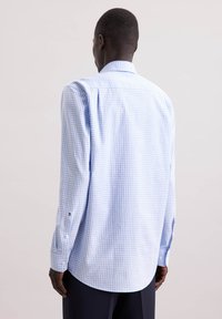Camicia a maniche lunghe con fantasia a quadri blu e bianca, polsini abbottonati, tessuto morbido, colletto classico e vestibilità rilassata.