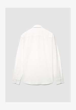 Camicia bianca a maniche lunghe con vestibilità rilassata, collo rigido, polsini abbottonati e tessuto strutturato. Superficie liscia con sottile lucentezza.