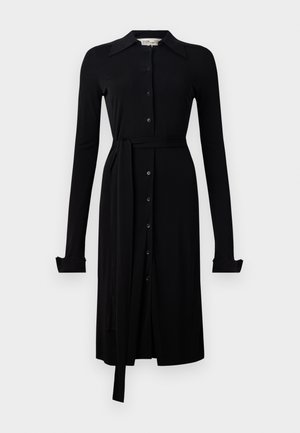 Schwarzes langärmliges Kleid aus glattem Material, mit durchgehender Knopfleiste, Kragen und einem Taillengürtel. Geknöpfte Manschetten und knielanger Saum.