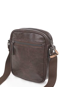 Bolso cruzado de cuero marrón con un acabado texturizado, compartimento principal con cremallera y un bolsillo frontal adicional. Correa de tejido ajustable.