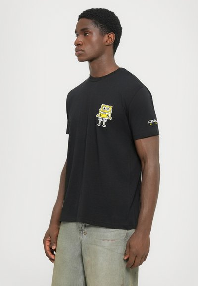 Black cotton t-shirt featuring a yellow SpongeBob SquarePants graphic on the chest and "ICEBERG" text detail on the sleeve.