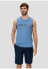 T-shirt sans manches bleue avec un logo imprimé en gris et bleu foncé, associée à un short sombre. Tissu en coton doux, coupe décontractée.
