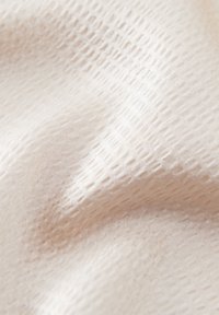Tissu texturé en crème pâle avec un motif subtil de points en relief, surface lisse et drapé doux. Idéal pour diverses applications textiles.