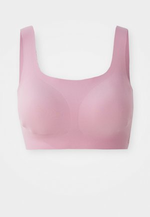Lichtroze draadloze sportbeha met brede banden en naadloze gevormde cups, ontworpen voor comfort en ondersteuning.