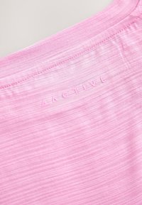 Sportshirt in Hellrosa, hergestellt aus weichem, strukturiertem Stoff. Mit einem geprägten "ACTIVE" Logo auf der Rückseite und einem Rundhalsausschnitt.