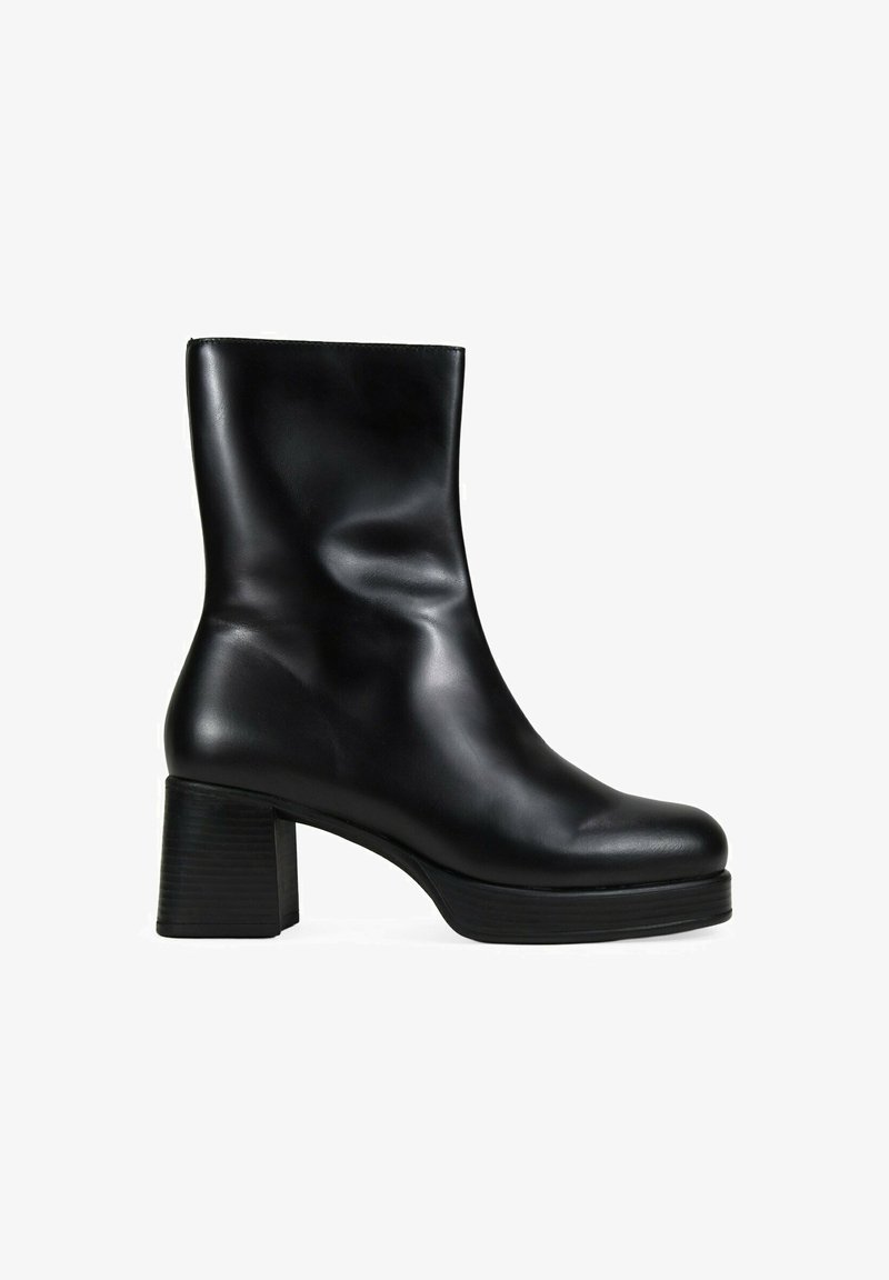 Botín negro de cuero hasta el tobillo con una textura suave y brillante, puntera redondeada y tacón cuadrado. Presenta un caña ajustada y elementos de diseño mínimos.