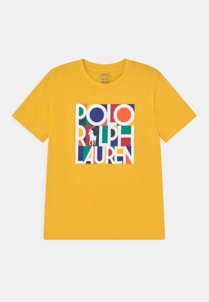 T-shirt jaune à manches courtes avec un logo bloc coloré Polo Ralph Lauren featuring une silhouette de joueur de polo au centre devant.