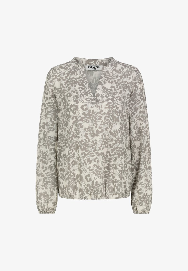 Lightweight blouse with a v-neckline, long sleeves, and elastic hem. Features a gray and cream abstract pattern on a soft fabric.