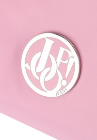 Tessuto rosa testurizzato con un distintivo logo circolare argentato che recita "JP! JEANS". Il logo contiene lettere intrecciate in un design moderno.