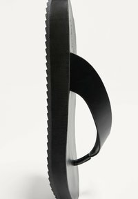 Flip-flop negru cu talpă din cauciuc texturat și suport plat pentru picior, având o curea în formă de Y și un suport pentru degete rotunjit.