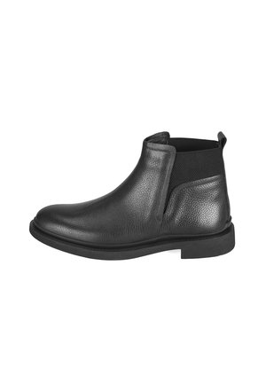 Bottine en cuir noir avec une finition texturée, panneaux latéraux en élasthanne, bout arrondi et semelle en caoutchouc plate. Design minimaliste, sans quincaillerie visible.