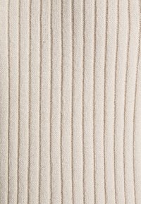 Tissu crème avec une texture verticale côtelée uniformément espacée et une surface douce, légèrement duveteuse.