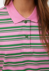 Roza in zelena striped polo majica z ovratnikom in dvema gumbkoma. Mehak material z gladko teksturo.