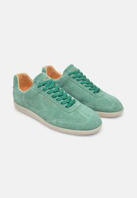 Sneaker verde in suede con finitura testurizzata, fodera arancione a contrasto e lace abbinati. Presenta un design low-top e suola in gomma.