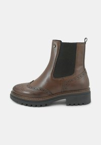 Stivale alla caviglia in pelle marrone con pannello laterale testurizzato, dettagli brogue e suola in gomma. Presenta un linguetta per la calzata e dettagli metallici.