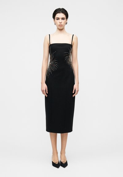 Robe midi noire à fines bretelles, ornée de motifs de feux d'artifice colorés en sequins sur les côtés. Tissu lisse, silhouette ajustée, longueur au genou.