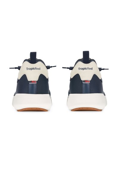 Zapatillas deportivas azul marino con acentos en color beige, con una parte superior texturizada, una lengüeta y una suela intermedia blanca. Marca visible en la parte trasera.