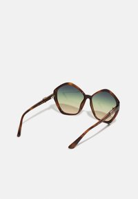 Ochelari de soare cu cadrul în formă octogonală, din material țestoasă, cu lentile cu gradient de la verde la maro și brațe elegante, curbate. Accente metalice pe cadru.