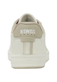 Zapatillas K-Swiss con una parte superior de cuero blanco, acentos beige, un cuello de talón texturizado y una suela ligera que presenta un discreto detalle a rayas.