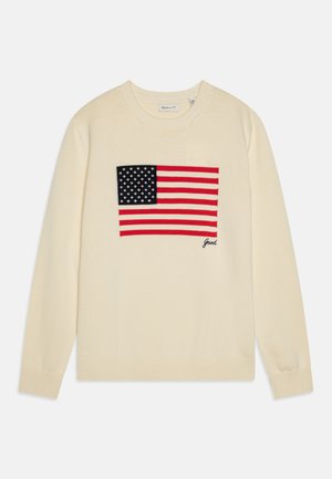 Kremfarget genser med strikket amerikansk flaggdesign i marineblått, rødt og hvitt. Ribbestrikkede mansjetter og kant, med logodetalj nederst.