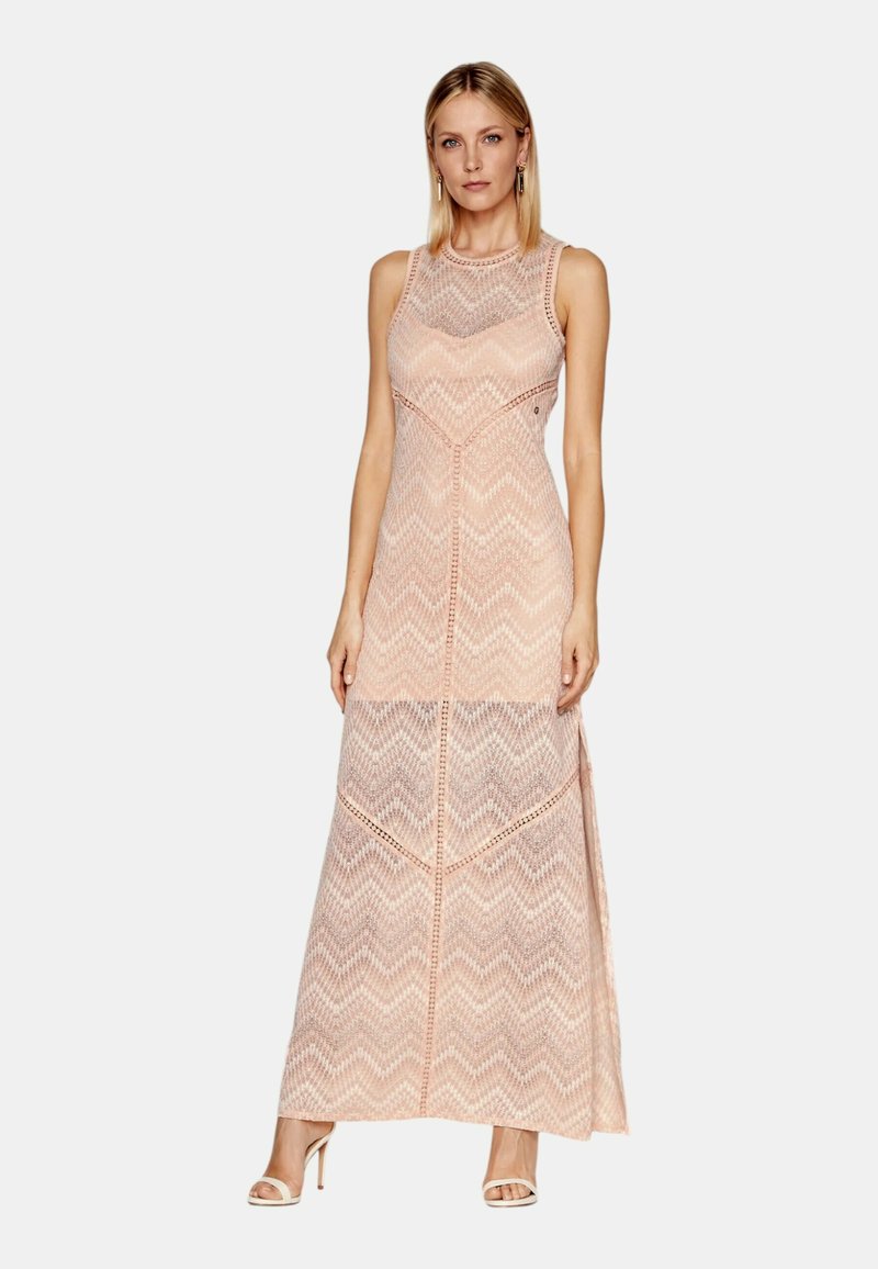 Abito senza maniche fino al ginocchio di colore rosa pallido, con motivo a zigzag e texture trasparente. Le cuciture piatte e le leggere aperture laterali arricchiscono il design.