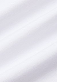 Biały materiał o gładkiej, miękkiej fakturze i subtelnym prążkowanym wzorze, sfotografowany pod kątem, aby podkreślić jego układ i połysk.