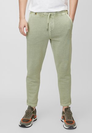 Pantalones jogger en verde claro, ajustados y confeccionados en tela suave, con cintura elástica y cordón de ajuste, y bolsillos laterales.
