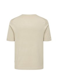 T-shirt beige a maniche corte con una texture morbida, scollatura tonda e dettagli di cucitura sottili sulle spalle e sull'orlo. Nessun logo o motivo visibile.