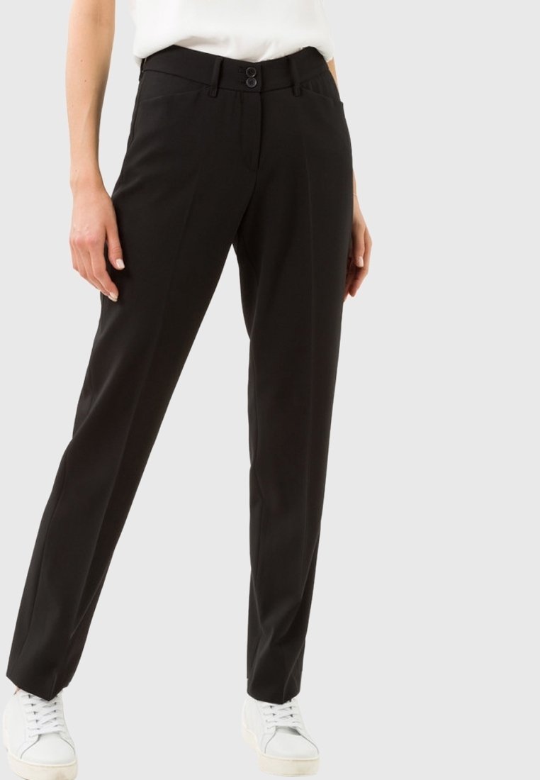 Černé kalhoty na míru se slim fit, vybavené dvojitým zapínáním na knoflíky a poutky na opasek. Hladká textura, minimalistický design, v kombinaci s bílými teniskami.
