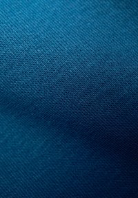 Texturerad tyg i en djupblå färg, med en slät yta och ett fint, diagonalt vävsmönster. Inga ytterligare detaljer eller accenter närvarande.