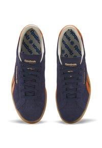 Sneakers in suede blu navy con suola in gomma, dettagli arancioni, punta perforata e branding dorato sulla linguetta e sul lato.