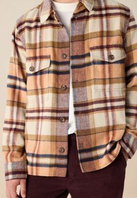 Geruite overshirt in beige, oranje, bruin en marineblauw, gemaakt van zachte stof, met twee borstzakken en knoopsluitingen. Getextureerde afwerking.