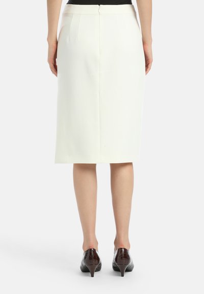 Valkoinen kynähame, jossa on sileä rakenne, polven pituinen malli ja takatasku. Yhdistetty tummanruskeisiin korkokenkiin.