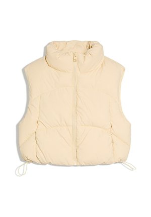 Kremno obarvan brezrokavnik iz odejnega materiala s visokim ovratnikom, sprednjim zadrgo in nastavljivimi vrvicami na robu.